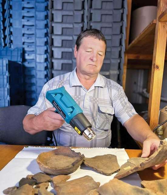 Археолог готує до зберігання тисячолітні уламки, просушуючи їх спеціальним феном.